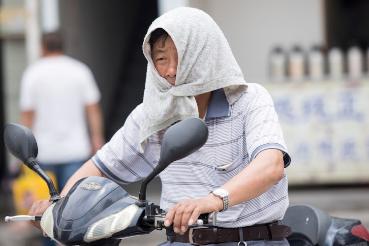 A man is seen with a towel tied around his head to escape hot weather during heatwave in Zhejiang province, China, in this file photo.Picture: REUTERS