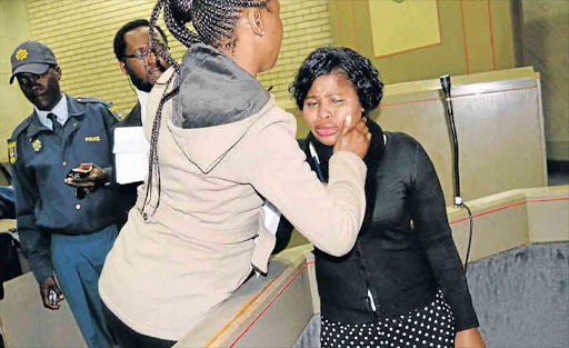 A teary Aviwe Bila is being consoled during her appearance at the Mthatha High Court yesterday