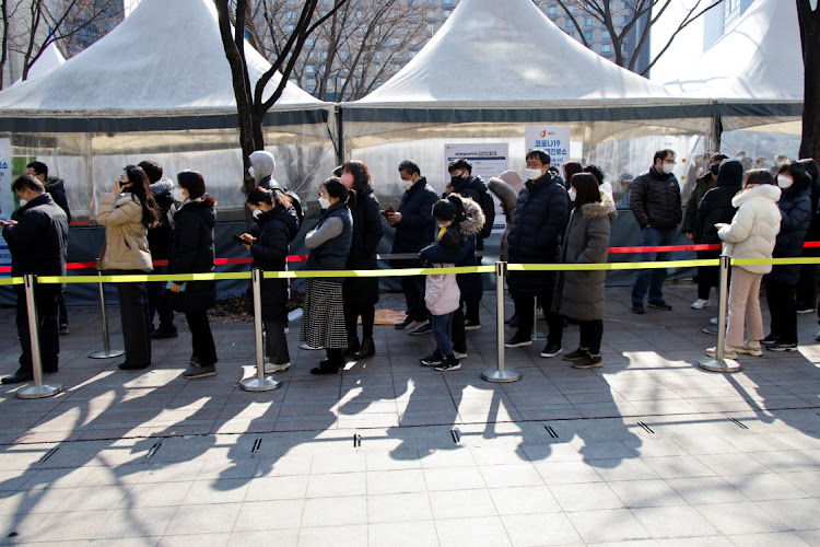 People wait in line to undergo the coronavirus disease (Covid-19) test at a temporary testing site set up at City Hall Plaza in Seoul, South Korea, February 10, 2022.