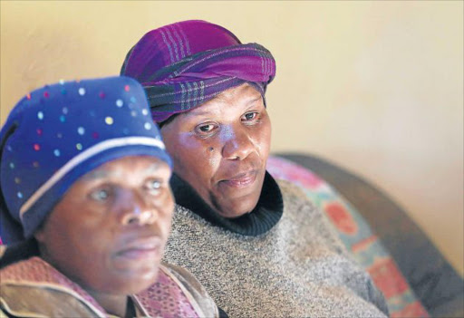 DEVASTATED: Widow Nosipho Kondlo, far right, in tears seen here with her sister Nosipho Gusha after she was prevented from attending the funeral of her 84-year-old husband, Bonisile Kondlo