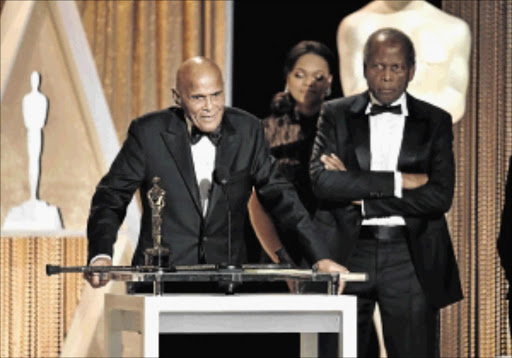 HONOURED: Harry Belafonte, left, accepts the Jean Hersholt Humanitarian Award from actor Sidney Poitier, right, during the Academy Of Motion Picture Arts And Sciences' 2014 Governors Awards at The Ray Dolby Ballroom at Hollywood & Highland Center on Saturday PHOTO: Kevin Winter/Getty Images