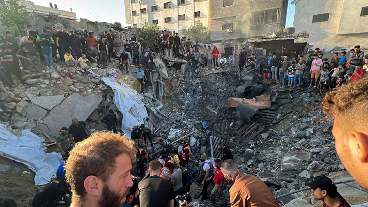 Palestinians gather at the site of an Israeli strike on a house, amid the ongoing conflict between Israel and Palestinian Islamist group Hamas, in Gaza City on October 21 2023. Picture: REUTERS/Mutasem Murtaja