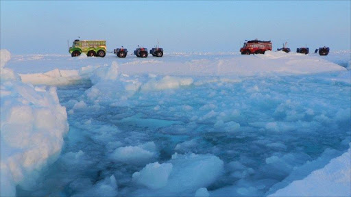 In this undated image released by the Marine Ice Automobile Expedition, two trucks used by the expedition members cross the North Pole. File photo.