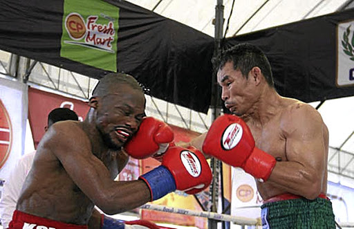 Simphiwe konkco absorbs a right from WBC reigning strawweight champion Wanheng Menayothin on Friday.