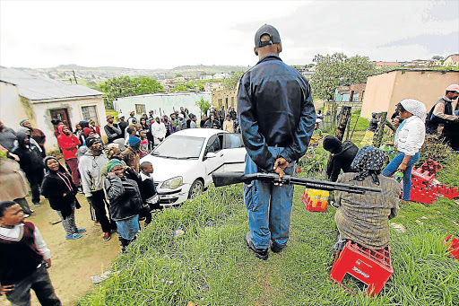 ON GUARD: Police had to provide armed protection for foreign shop owners in Grahamstown last month after their stock was looted Picture: DAVID MACGREGOR