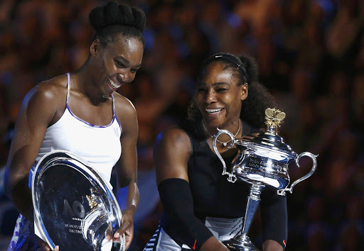 Serena Williams of the U.S. reacts as she holds her trophy after winning her Women's singles final match against Venus Williams of the U.S. .REUTERS/Thomas Peter