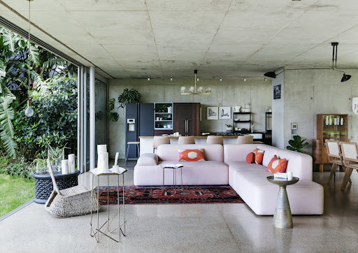 The Beatrix modular sofa in the open-plan living room was designed by the homeowner Lisa Twyman. The Tray tables with brass legs are by Dokter and Misses.