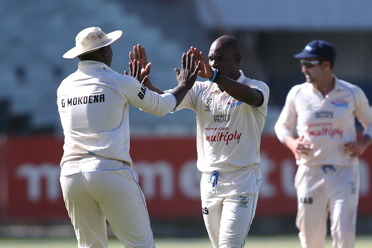 Grant Mokoena congratulates his Titans teammate Junior Dala during the match.