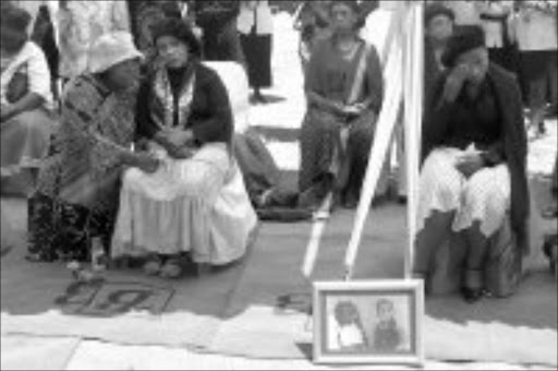 GRIEVING: Grace Mokoena, left, and her daughter Mapule at funeral of thier daughters, Michelle and Telma, at Phumlani Cemetery in Daveyton yesterday. Pic. Peter Mogaki. 24/10/2006. © Sowetan