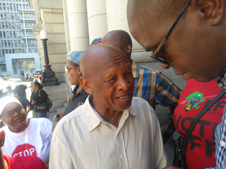 Uyinene's uncle, Vuyani Mrwetyana, talks to Cape Town councillor Patrick Mngxunyeni outside the high court in Cape Town following Luyanda Botha's sentencing.