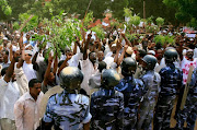 Sudanese policemen stand guard opposite demonstrators during a protest against an amateur film mocking Islam outside the German embassy in Khartoum on September 14, 2012. The low-budget movie called 