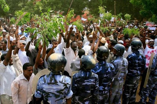 Sudanese policemen stand guard opposite demonstrators during a protest against an amateur film mocking Islam outside the German embassy in Khartoum on September 14, 2012. The low-budget movie called "Innocence of Muslims", which ridicules the Prophet Mohammed and portrays Muslims as immoral and gratuitously violent, has triggered protests in several countries.
