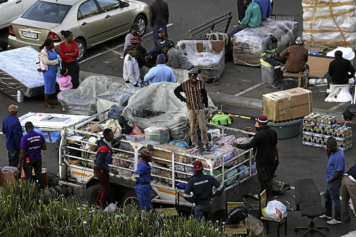 Foreign nationals pack trailers with goods to send home at a garage in Parktown, Johannesburg./ALON SKUY