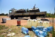 Water containers ready to be filled from a water truck outside the Klipdrift water treatment plant in Hammanskraal, Tshwane. 