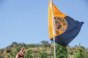 A fan holds a Kaizer Chiefs flag outside the club's headquarters at Naturena.