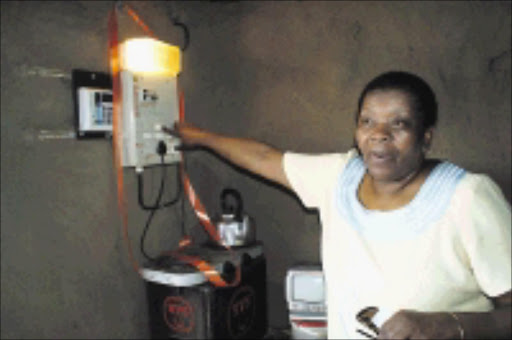 SWITCHED ON: Minister Buyelwa Sonjica connects a child-headed home to electricity. 22/02/09. Pic. Mhlaba Memela. © Sowetan.