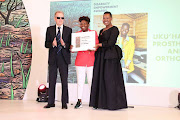Soweto-born Sibongile Mngadi, the founder and owner of Uku'hamba Prosthetics and Orthotics, receives her prize of a R1,3m in grant funding and business development support from Small Business Development minister Stella Ndabeni-Abrahams and SAB Foundation Trustee Dr. William Rowland, after her innovation scooped first prize at the SAB Disability Empowerment Awards.