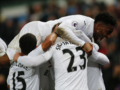 Swansea’s Martin Olsson celebrates with Leroy Fer and teammates against Leicester City February 2. /REUTERS