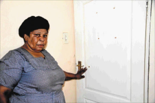 DISTRAUGHT: Paulinah Sambo points at a bullet hole where her granddaughter Sophy was allegedly shot by her husband on Sunday night . PHOTO: ELIJAR MUSHIANA