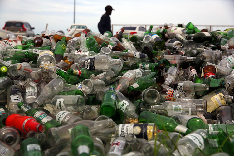 Gathered piles of empty bottles littered on the East London beachfront.