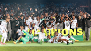 Orlando Pirates players celebrates lifting the 2023 Nedbank Cup trophy after the final against Sekhukhune United at Loftus Versfeld in May 2023.