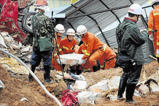 Rescue workers work at the site after a landslide hit an industrial park in Shenzhen, Guangdong province, December 21, 2015.