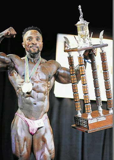SHAPING UP: East Londoner Thulasizwe Sifatyi holds the trophy for the overall winner at the buffalo City District Championships on Saturday night. Picture: MARK ANDREWS