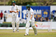 South Africa's Dean Elgar (R) walks off the field after his dismissal by Sri Lanka's Dilruwan Perera (not pictured) during the first test in Galle, Sri Lanka on July 14, 2018. 