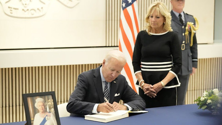 President Joe Biden, seen signing a book of condolences to the Queen, will attend along with First Lady Jill Biden