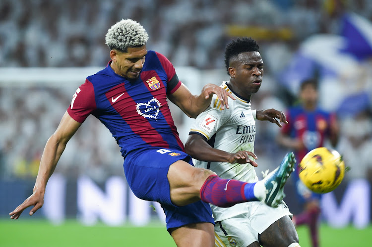 Barcelona's Ronald Araujo vies for the ball wrwith Real Madrid's Vinicius Junior