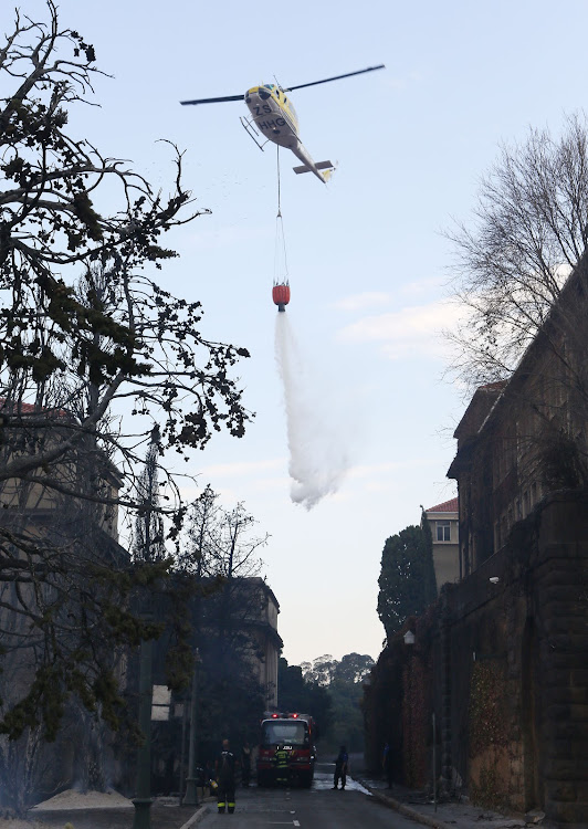 A helicopter water bombs the fire near the Jagger Library at the University of Cape Town.