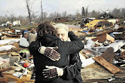 Martha Righthouse comforts neighbour Debbie Gilbert amid the ruins of Gilbert's home in Marysville, Indiana. The latest in a series of powerful tornadoes cut a broad swathe across the US Midwest and southeast, killing at least 38 people in four states Picture: AARON BERNSTEIN/GALLO IMAGES