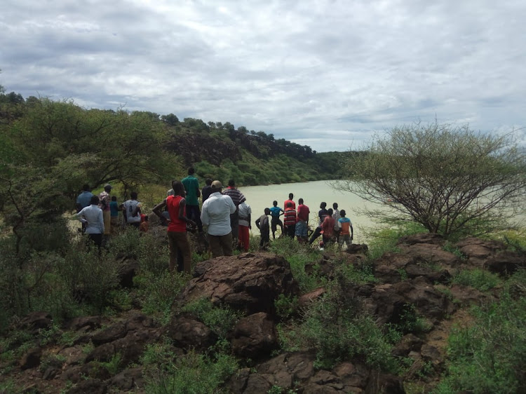 Residents watch helplessly during the search mission of a missing 10-year old boy in Lake Baringo on Friday.
