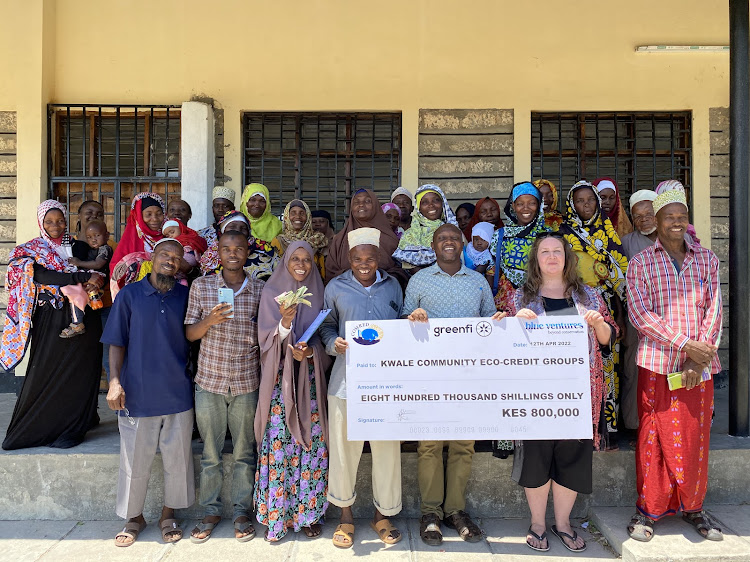 Bodo Beach Management Unit chairman Mohammed Mwangolo, Comred director Patrick Kimani and Blue Ventures outreach manager Lisa Mouland pose for a photo with Bodo group members during fund disbursement in Bodo village, Msambweni, Kwale, on April 13