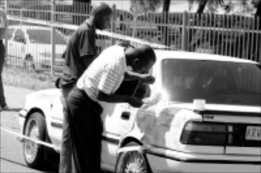 20091022 BMA Nine suspects have been arrested in connection with double robberies at a Nedbank and a jewelery store at the Menlyn Retail Park in eastern Pretoria. Seen here are police dusting the car for fingerprints from the to getaway car. PIC: BAFANA MAHLANGU. 22/10/2009. © SOWETAN