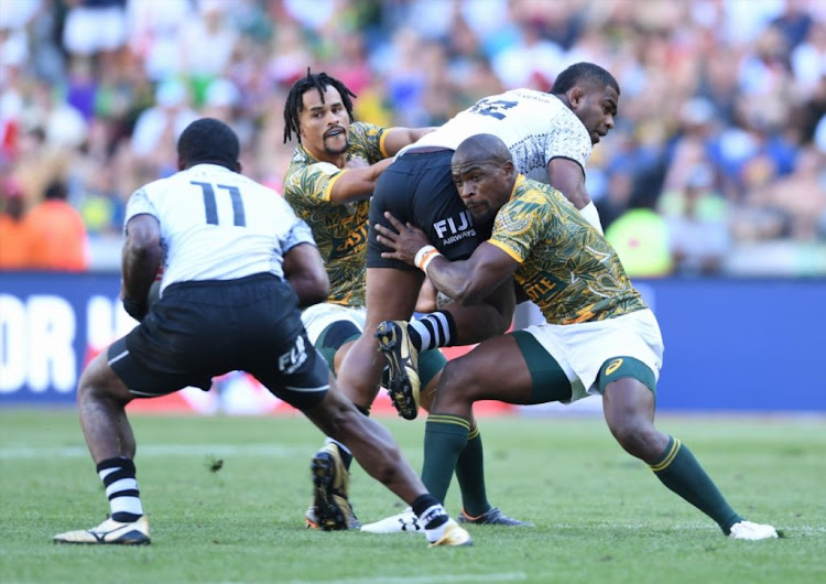 Vatemo Ravouvou of Fiji offloads while being tackled by Siviwe Soyizwapi of SA during day 2 of the HSBC Cape Town Sevens match 39, Cup Semi Final match between SA vs Fiji at Cape Town Stadium on December 9 2018.