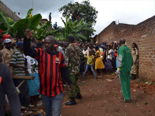-Kitui town gather around a house at the Kunda Kindu estate where a KDF soldier shot his girlfriend dead and killed himself with the same weapon in April this years. Photo by Musembi Nzengu