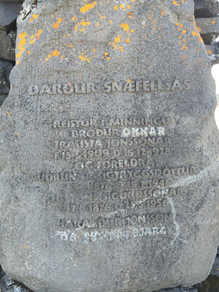This stone plaque is also on the Barður Snæfellsás statue in Arnarstapi, Iceland. It reads: Barður Snæfellsás Erected in memory of our brother, Trausti Jónsson, born March (?) 13 1909, D December 16, ...