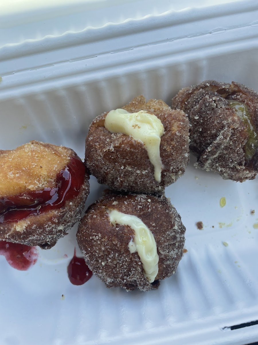 Gluten-free Mochi Donuts - made fresh; comes in a pack of 6. This photo shows six mochi donuts: 2 with strawberry sauce, 2 with pineapple sauce and 2 with a vanilla cream.