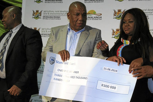 Mpumalanga MEC for agriculture, rural development and environmental affairs, Vusi Shongwe hands over a R300,000 cheque to Khulile Mahlalela.