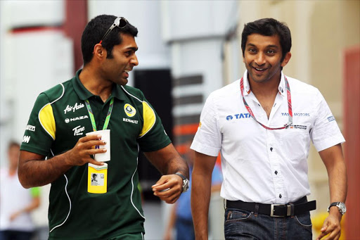 Karun Chandhok (L) of India and Team Lotus and Narain Karthikeyan of India and Hispania Racing Team walk in the paddock following practice for the European Formula One Grand Prix at the Valencia Street Circuit on July 24, 2011, in Valencia, Spain