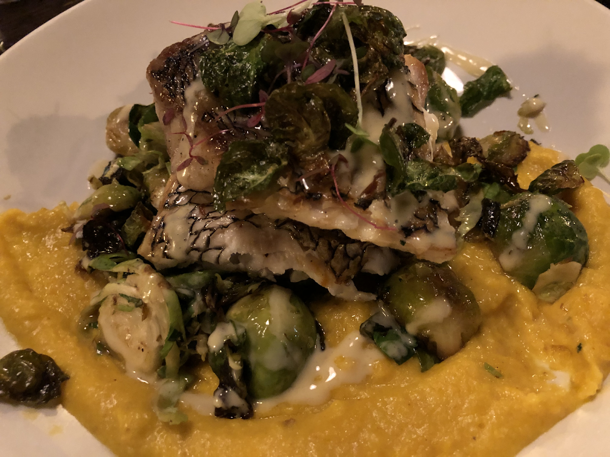 Sea Bass Over creamy pumpkin polenta, roasted brussels spouts and bacon 🥓
