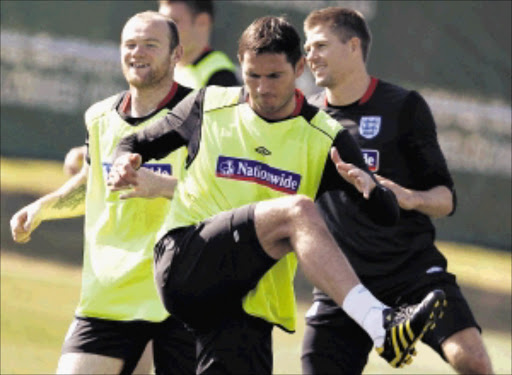England's Frank Lampard (C) warms up with Wayne Rooney (L) and Steven Gerrard during a World Cup soccer training session at the Royal Bafokeng Sports Campus near Rustenburg June 21, 2010. REUTERS/Darren Staples (SOUTH AFRICA - Tags: SPORT SOCCER WORLD CUP)