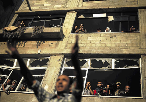 A Palestinian man at the scene of an Israeli air strike on a house in Gaza City yesterday. Ten Palestinian civilians were killed yesterday in Palestinian medics said Picture: SUHAIB SALEM/REUTERS