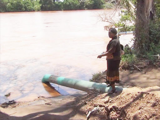POWER SHORTAGE: A woman stands near the water intake pipe on the banks of River Tana on June 12, 2013.