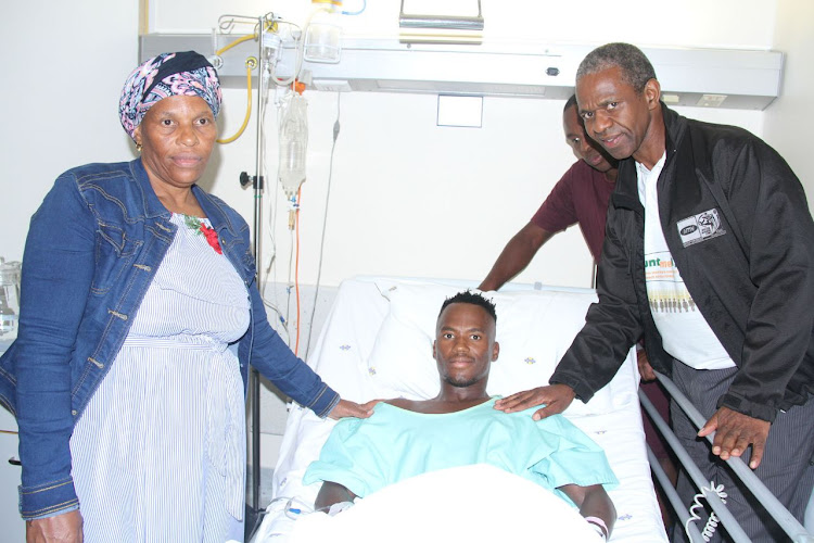 Triathlete Mhlengi Gwala in his hospital bed flanked by his mother, Fundi Magwaza, and KwaZulu-Natal MEC Sibongiseni Dhlomo.