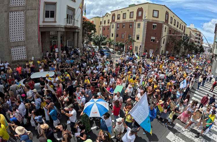 People march down a street in Santa Cruz de Tenerife, Spain, calling for change to the Canary Islands' tourism model.