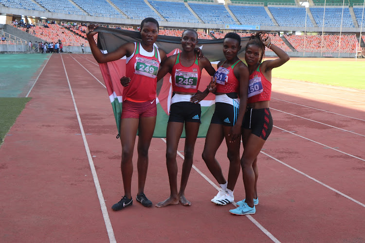 Kenyan sprinters (from L-R) Judy Kemunto, Marion Jepng'etich, Sylivia Chelangat and Sheila Jerono celebrate with Kenyan flag after winning the Girls 4X400m finals during the East Africa Athletics Junior Championships at Benjamin Mkapa National Stadium in Dar-es-Salaam, Tanzania.