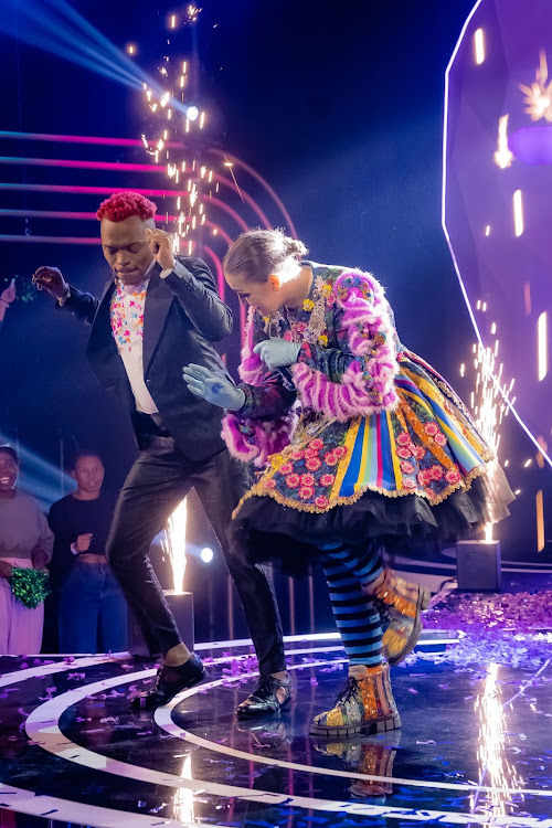 Award-winning singer songwriter Holly Rey dancing with detective Somizi onThe Masked Singer SA stage.