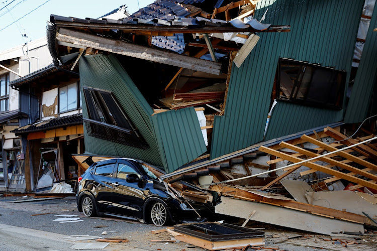 A damaged car and a collapsed house after an earthquake in Nanao, Ishikawa prefecture, in Japan on January 2 2024.